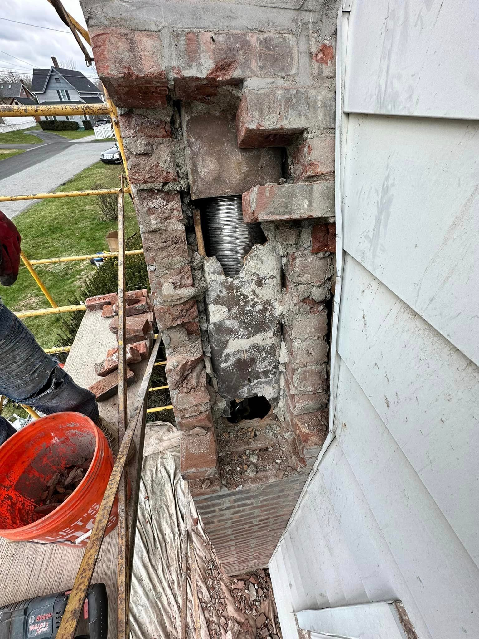 A person is working on a chimney on the side of a house.