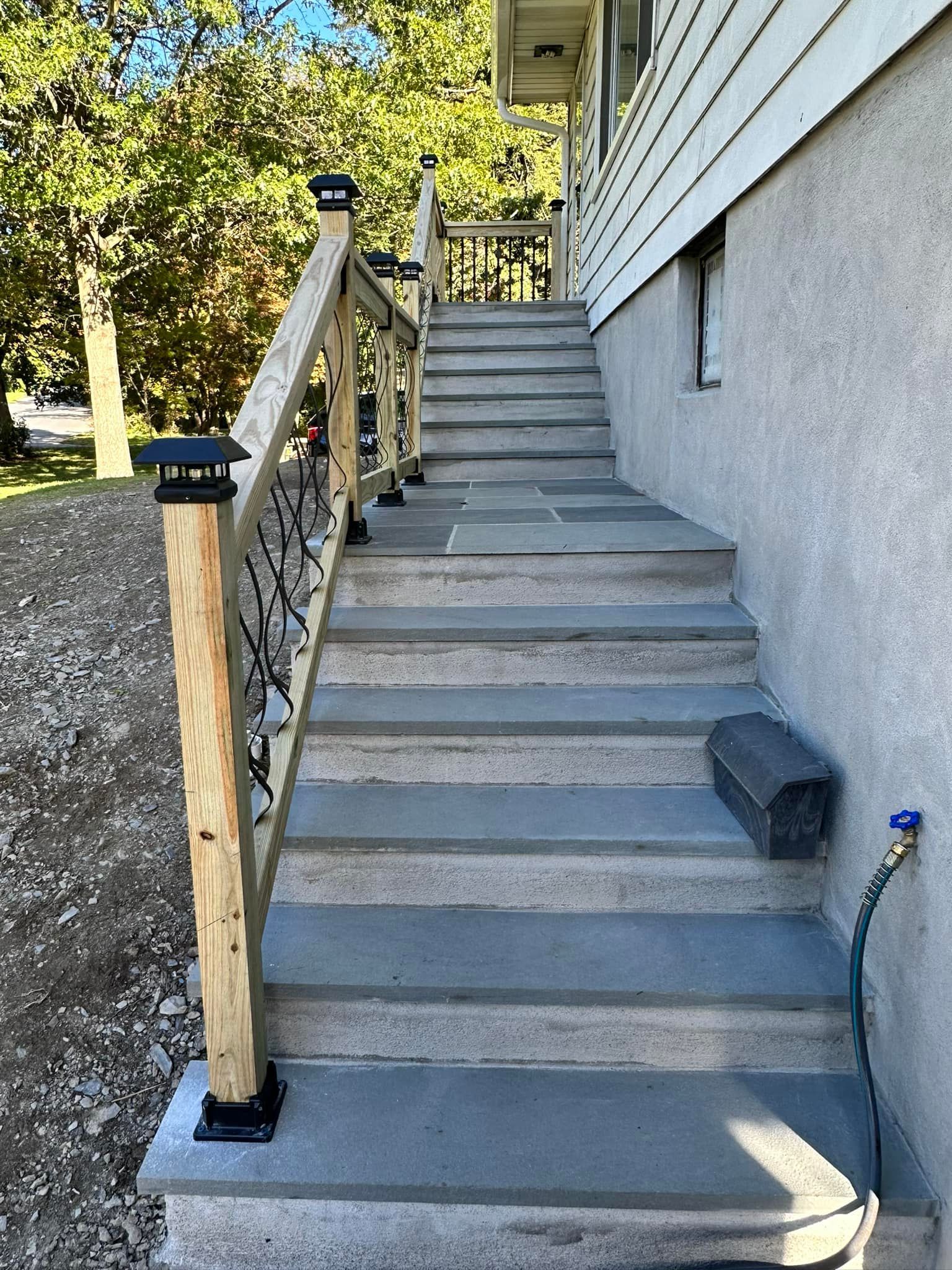 A set of stairs leading up to a house with a wooden railing.