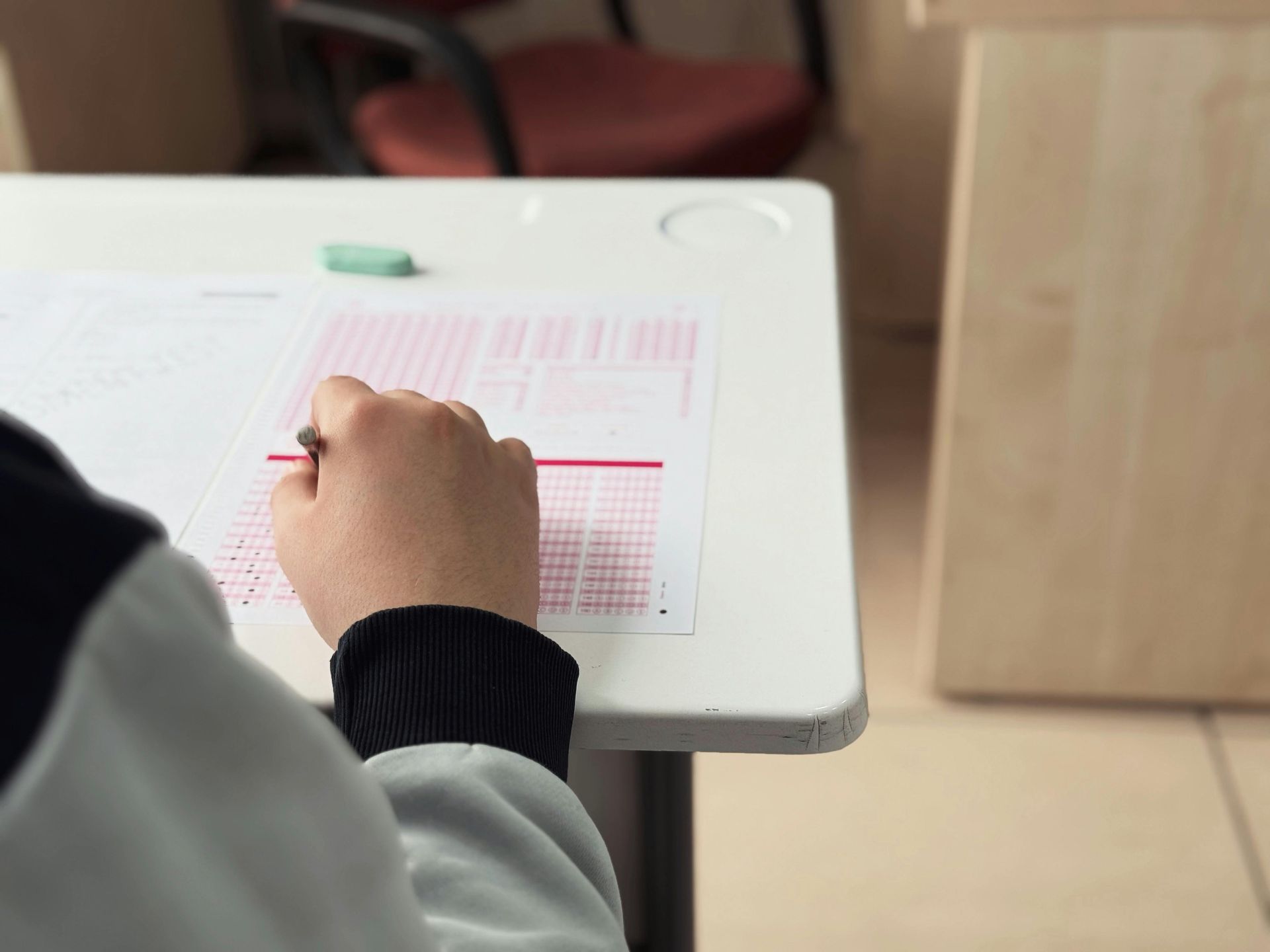 A woman is helping a boy with his homework at a table.