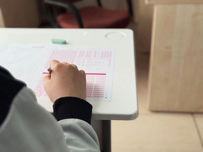 A woman is helping a boy with his homework at a table.