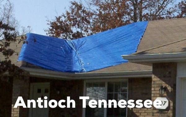 A blue tarp covers a large section of a damaged residential roof in Antioch, Tennessee.