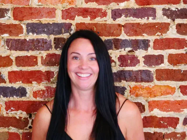 Hands holding a pharmacy box over bubble wrap.