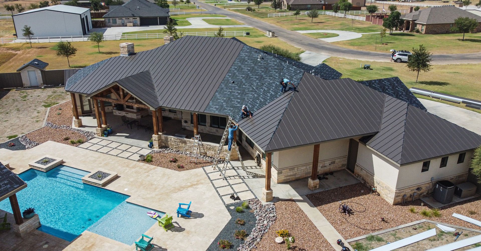 Aerial view of residential home with new standing seam metal roof installation