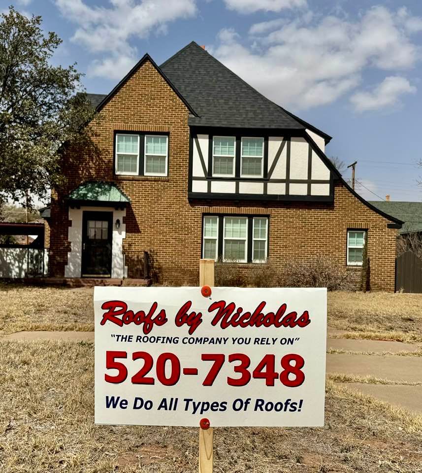 Roofs by Nicholas sign in front of brick house with Tudor style upper facade