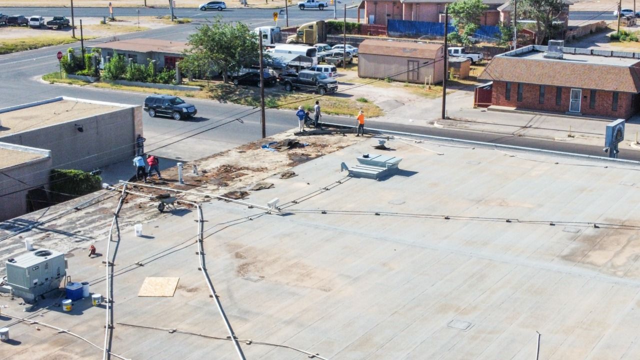 Aerial view of commercial building with white flat roof installation in Midland Texas