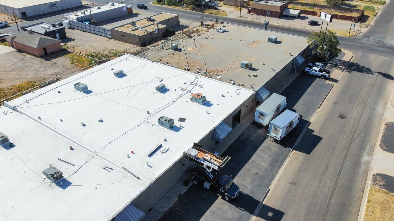 Aerial view of commercial building with white flat roof installation in Midland Texas