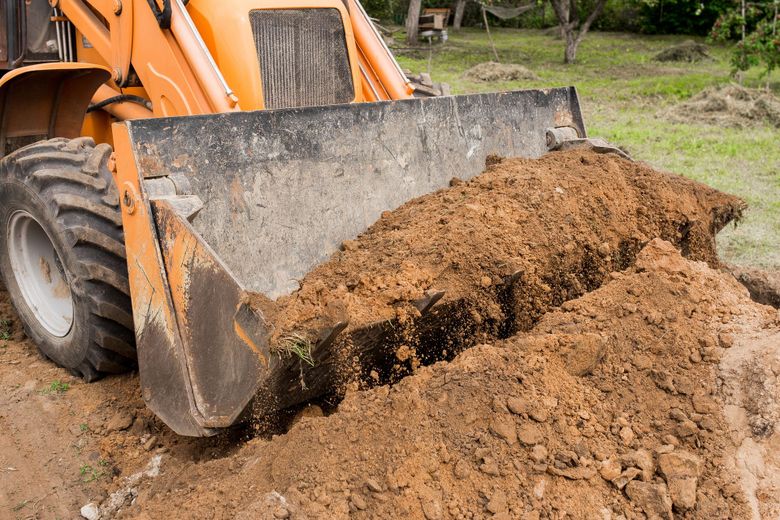 a bulldozer digging dirt in a field