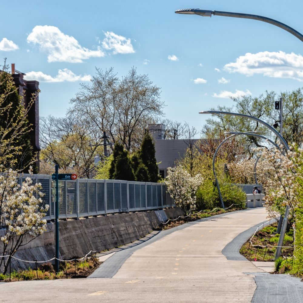 Brick building with tower, windows, and trees in the foreground.