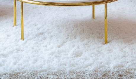 Eco Friend Carpet Clean - White shaggy rug with gold-legged coffee table.
