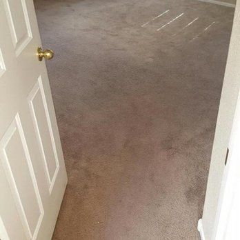 Eco Friend Carpet Clean - Open doorway into a room with brown carpet. Light streams in.