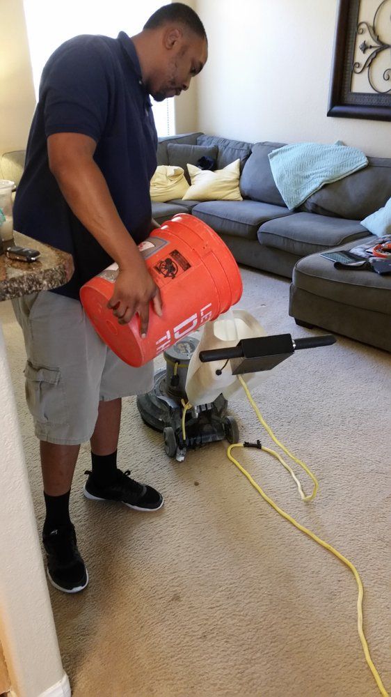 A man is using a vacuum cleaner in a living room.