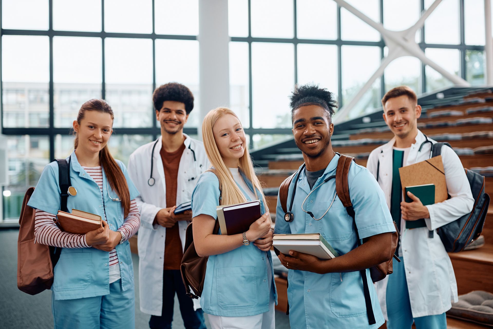 A group of medical students are posing for a picture in a lecture hall.