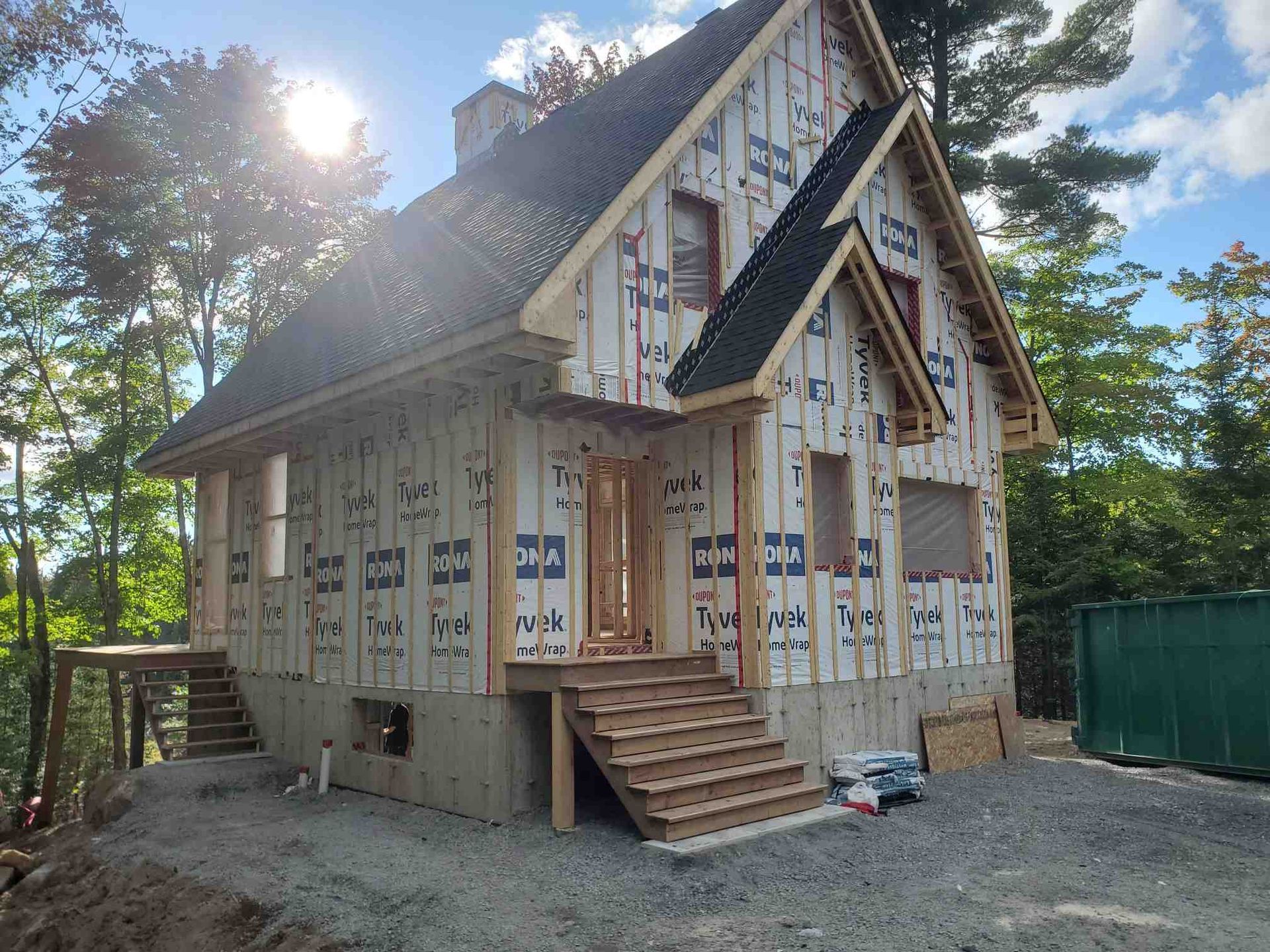 New house under construction with wood frame, porch, and unfinished siding.