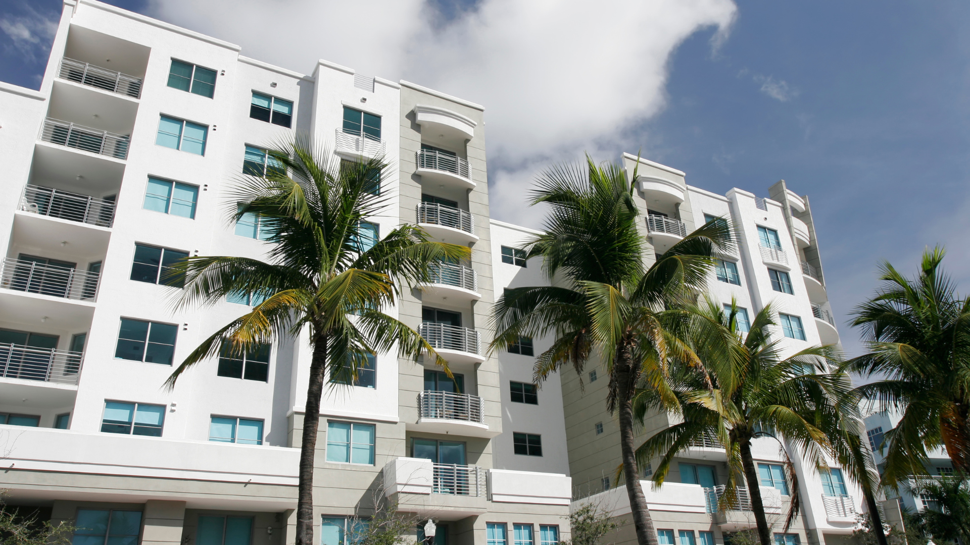 A large apartment building with the sun shining through the windows.