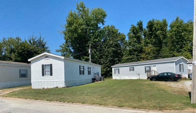 A person is fixing a leaking sink pipe with a wrench.