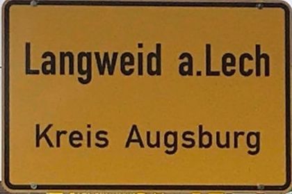 Zwei Lieferwagen stehen vor einem im Bau befindlichen Gebäude.