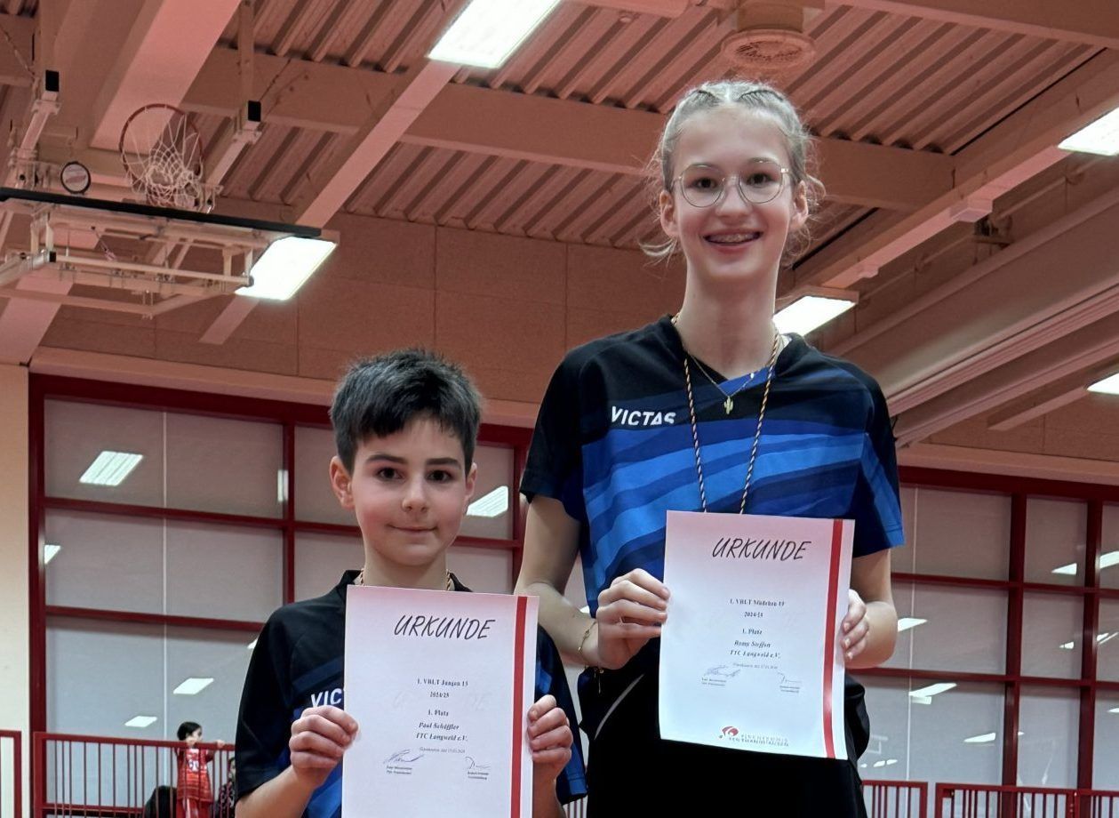 Ein Mädchen und ein Junge halten Zertifikate in einem Fitnessstudio