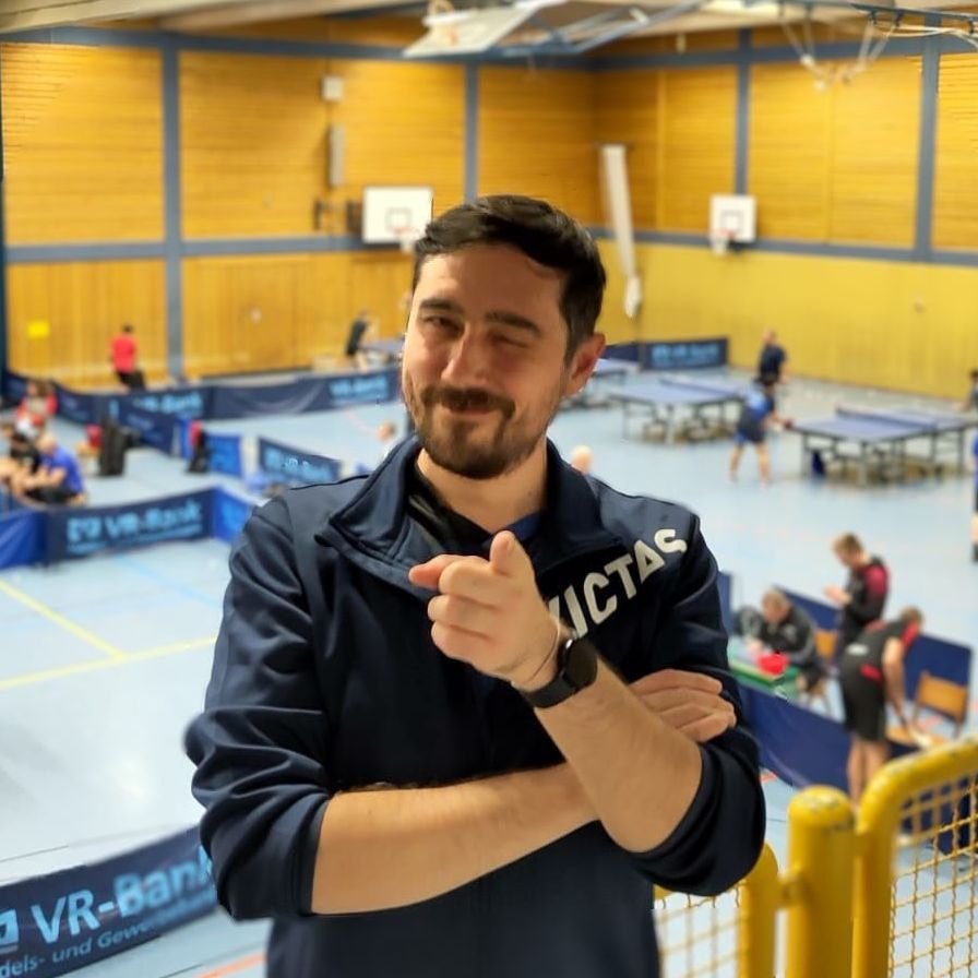 Ein Mann trägt ein blau-schwarzes Hemd mit der Aufschrift Victac