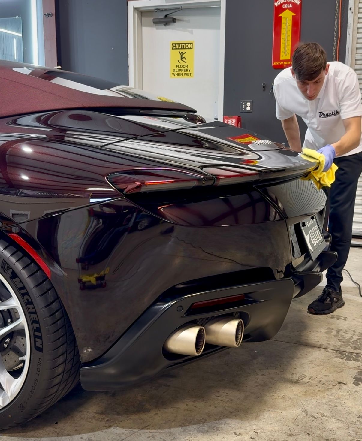a person wearing black gloves is polishing the hood of a car .