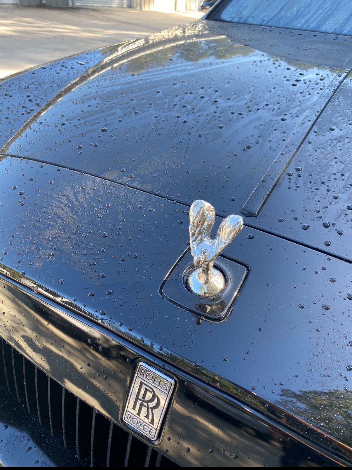 A black rolls royce car with a hood ornament on it