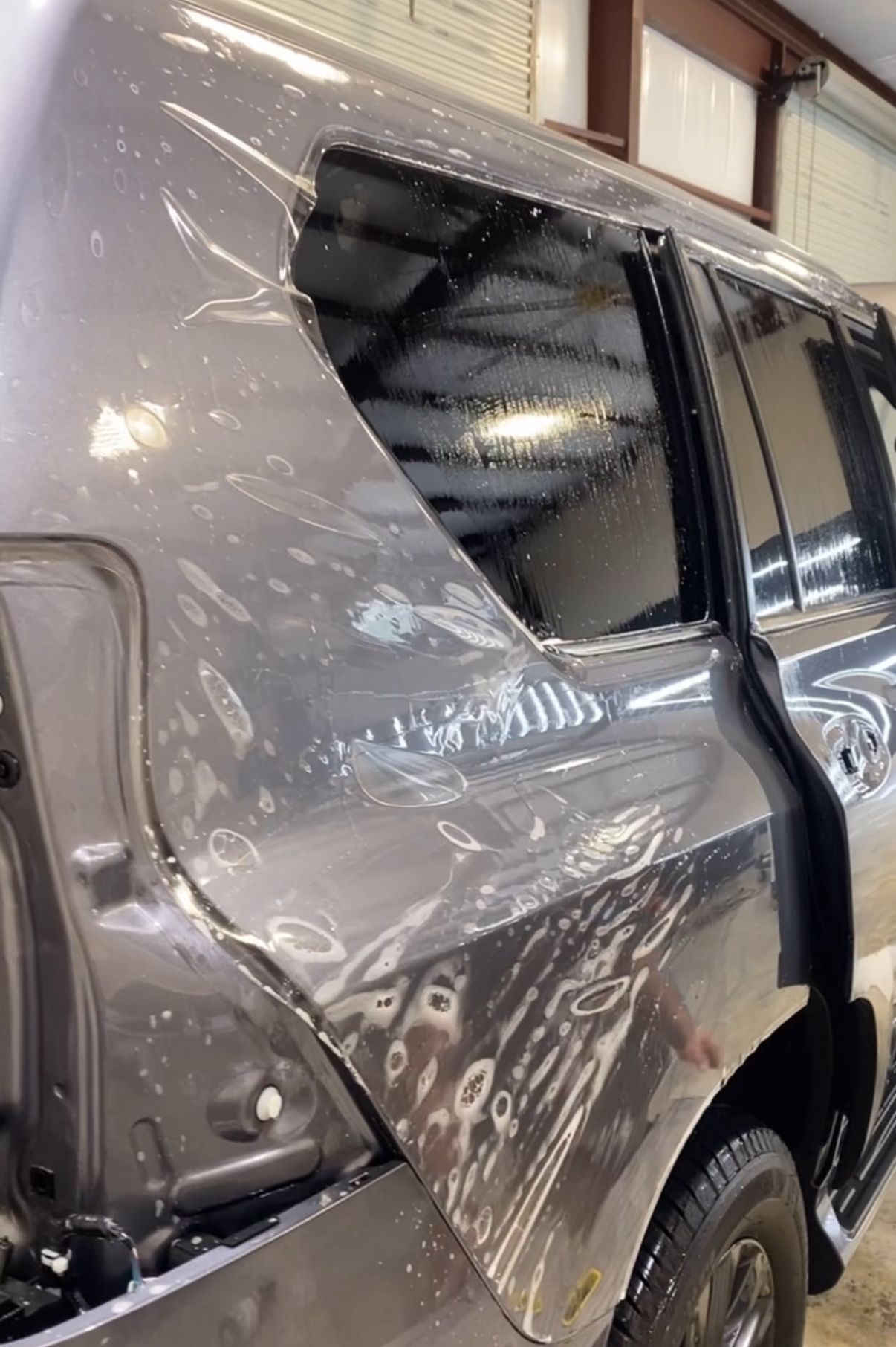 A car with a broken window is sitting in a garage.