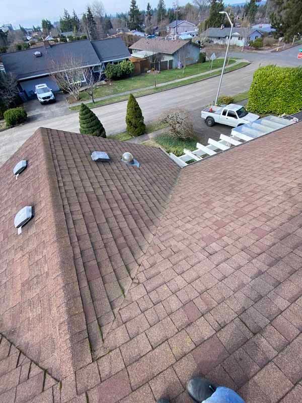 A person is standing on the roof of a house.