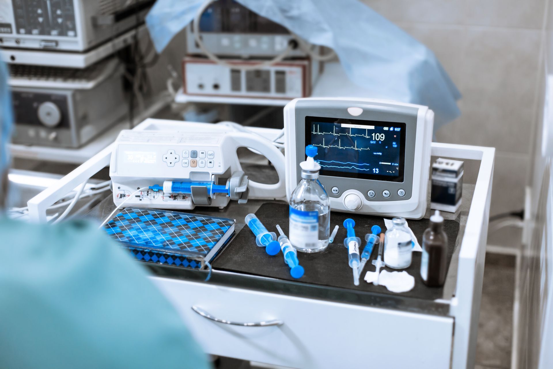 A surgical table with a monitor , syringes , and other medical equipment - Buford, GA - North Georgia Veterinary Specialists 