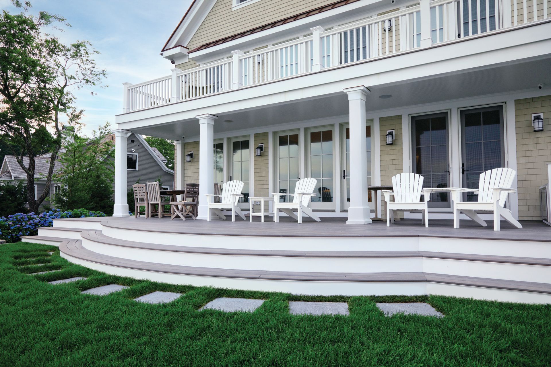 A large house with a large porch and chairs on it.
