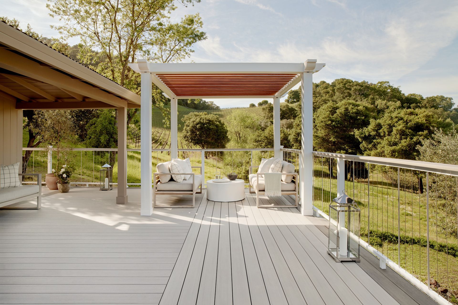A deck with a pergola and chairs on it