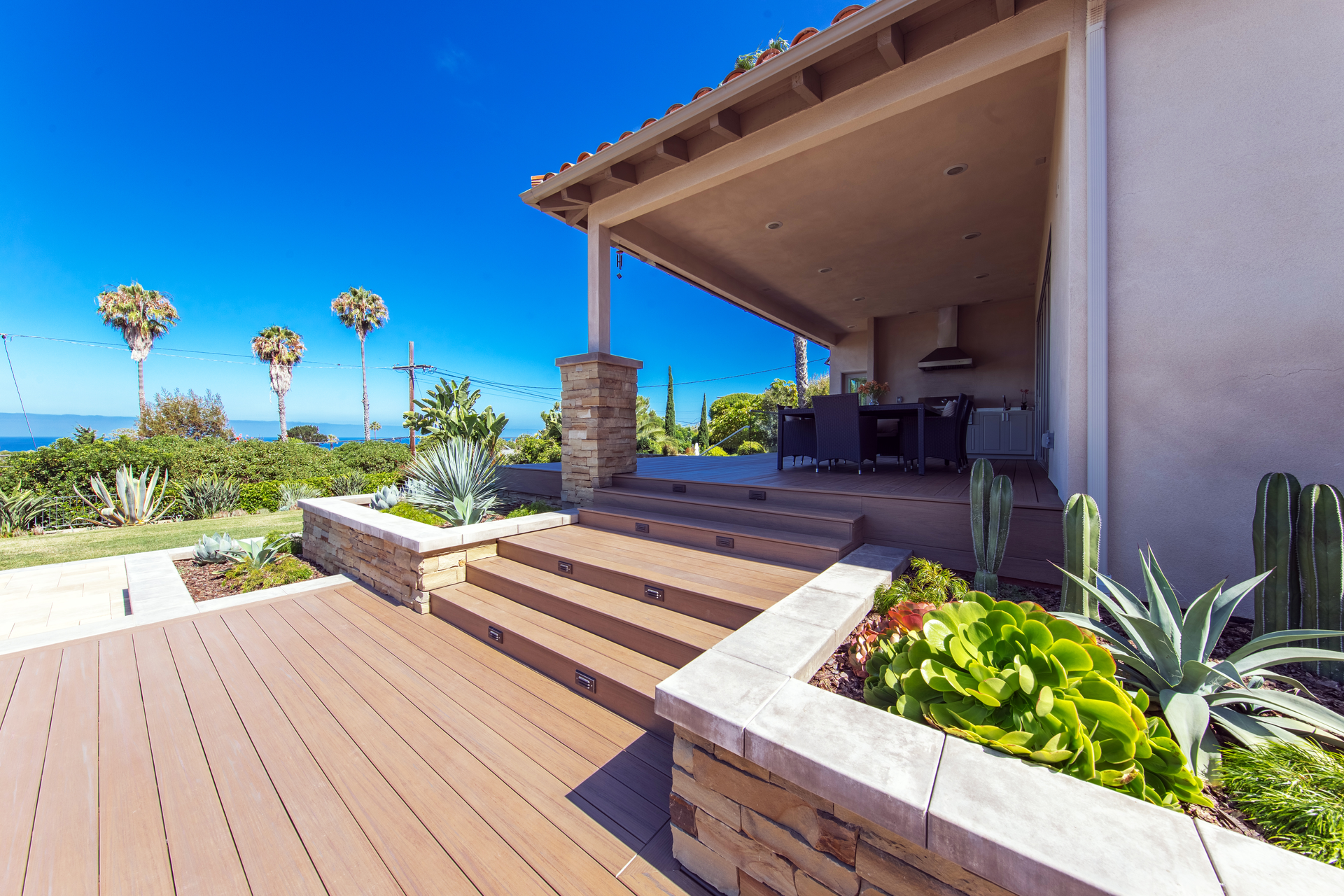A house with a wooden deck and stairs leading to it.