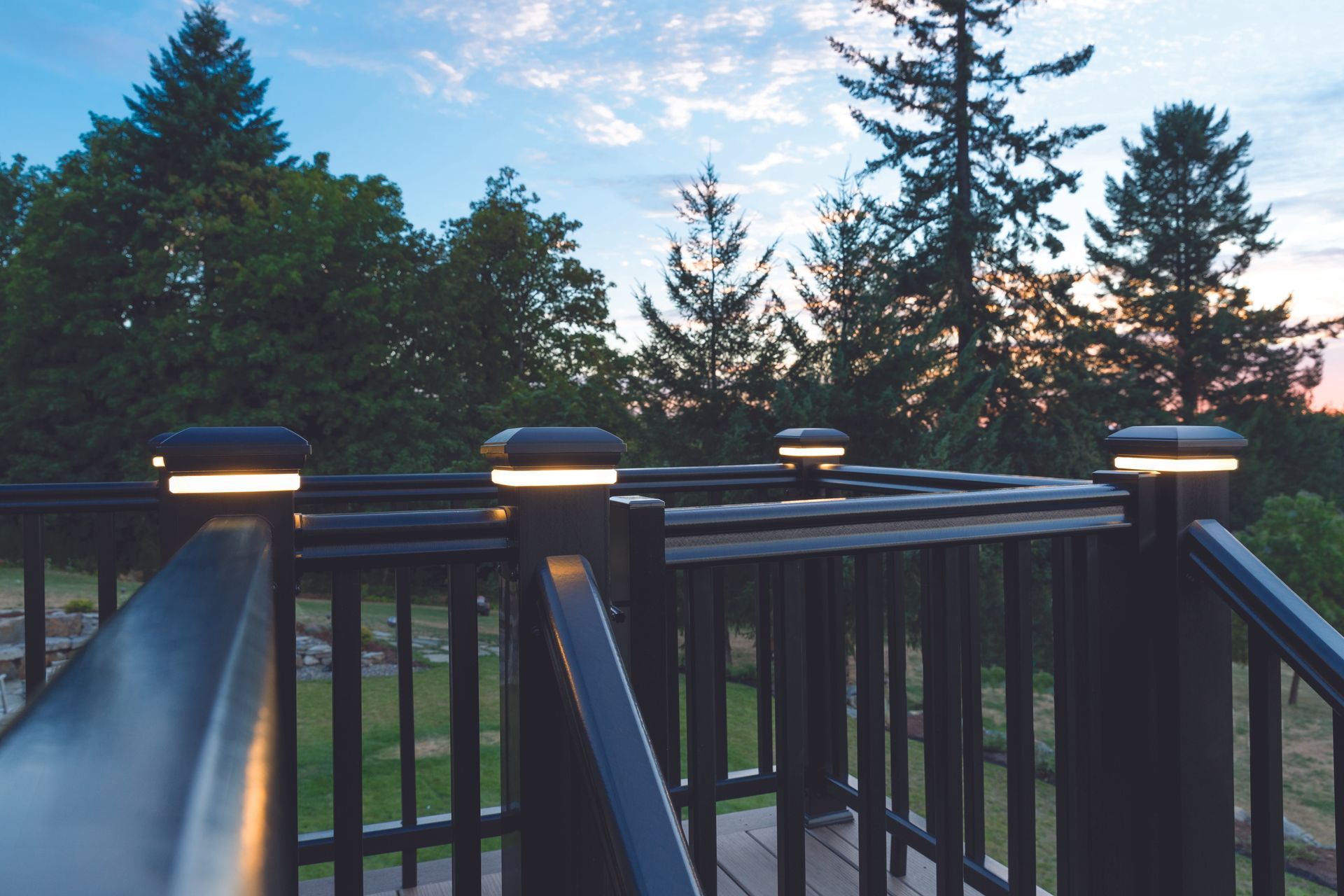 A deck with a fence and trees in the background