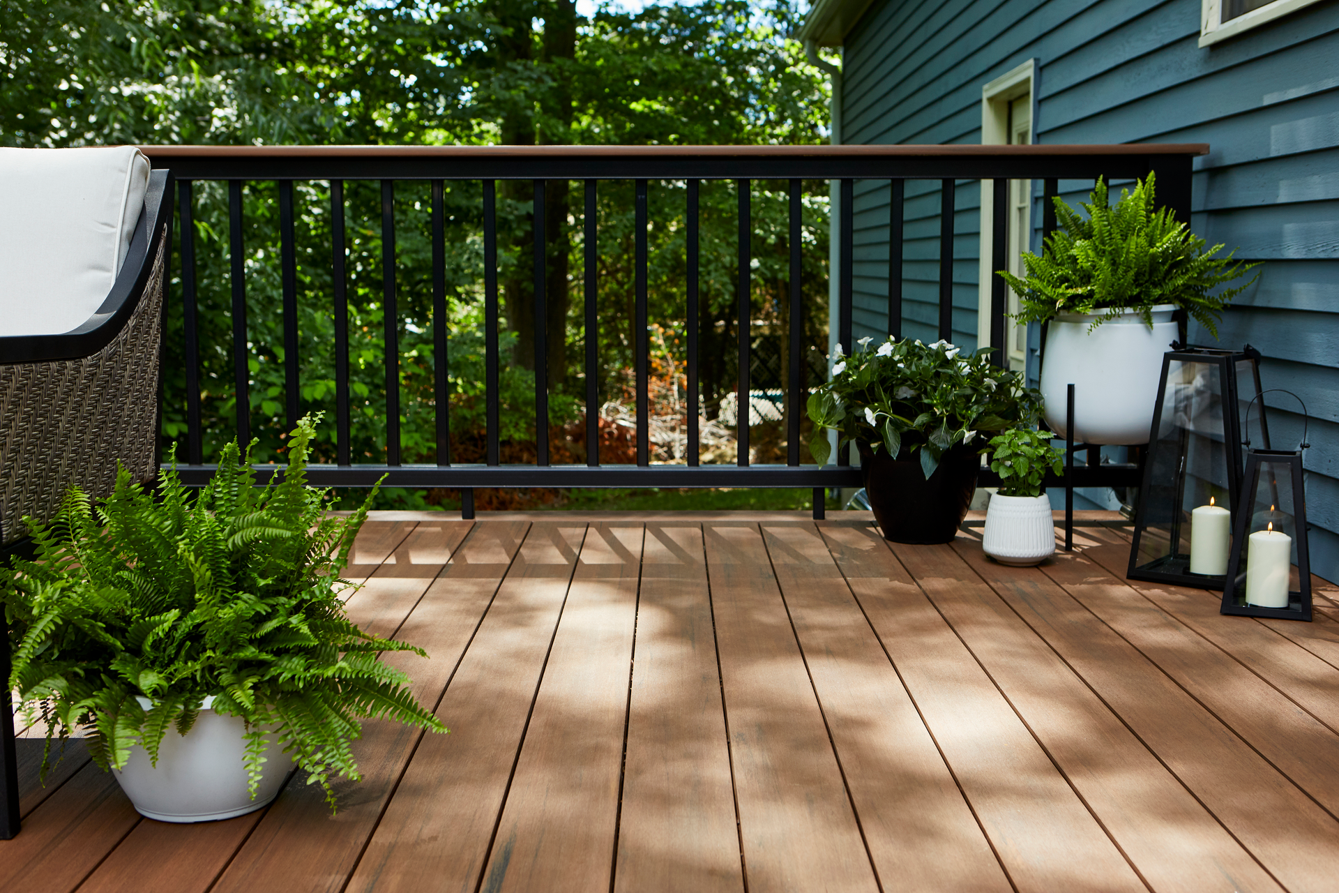 A wooden deck with potted plants and candles on it