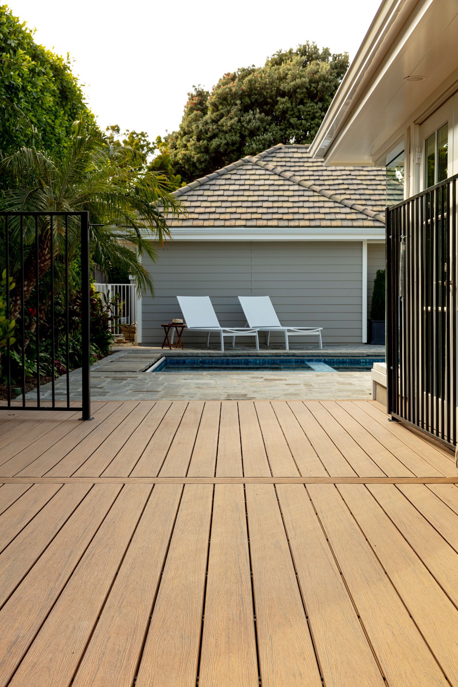 A wooden deck leading to a swimming pool