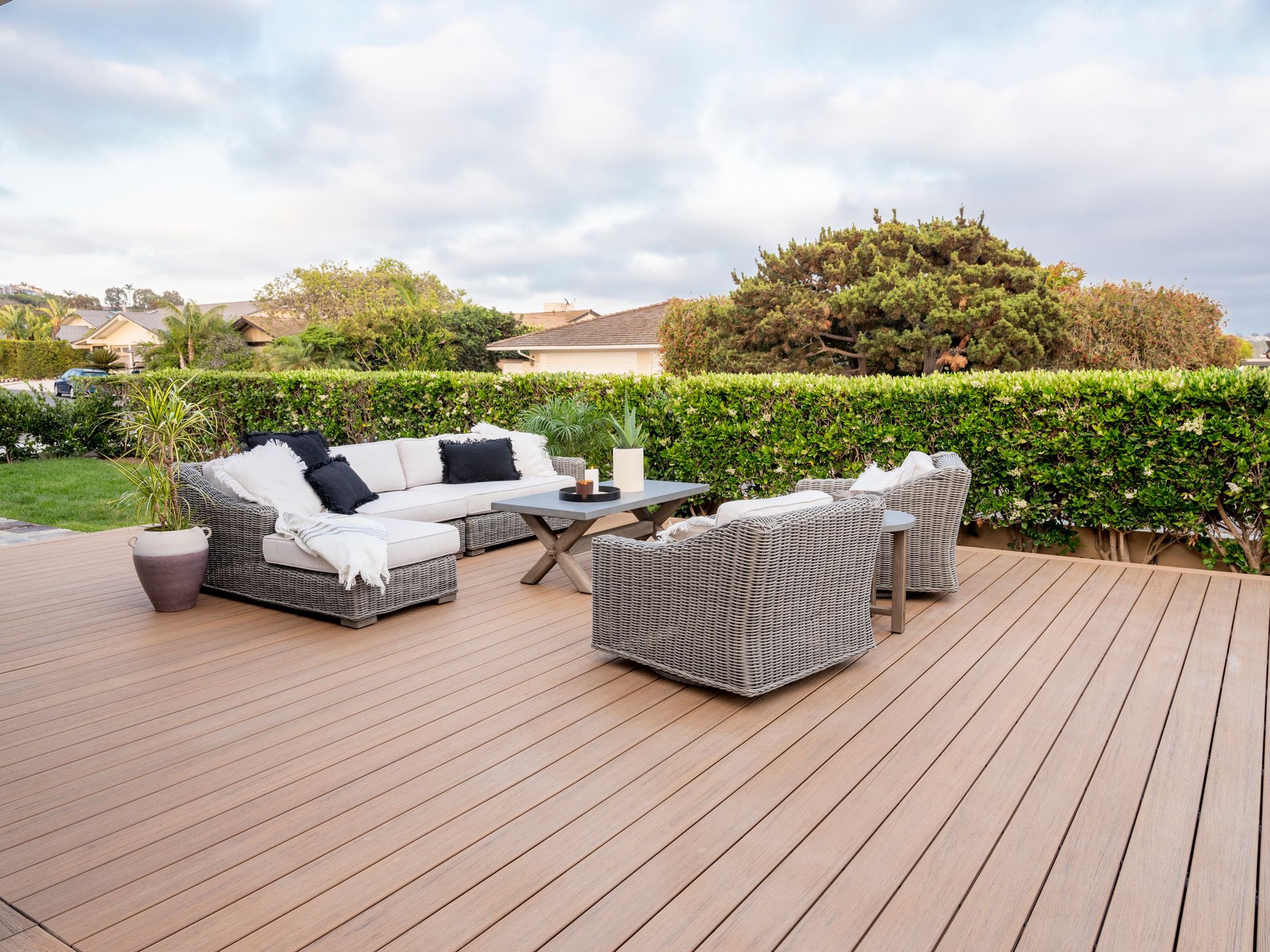 A wooden deck with a couch and chairs on it.