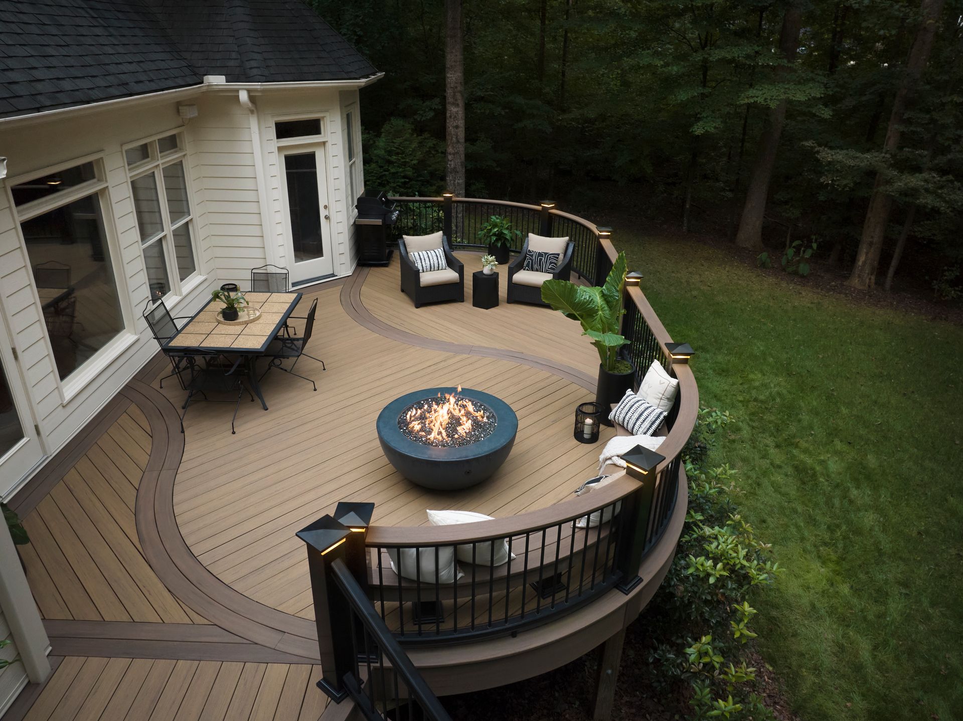 There is a fire pit on the deck of a house.