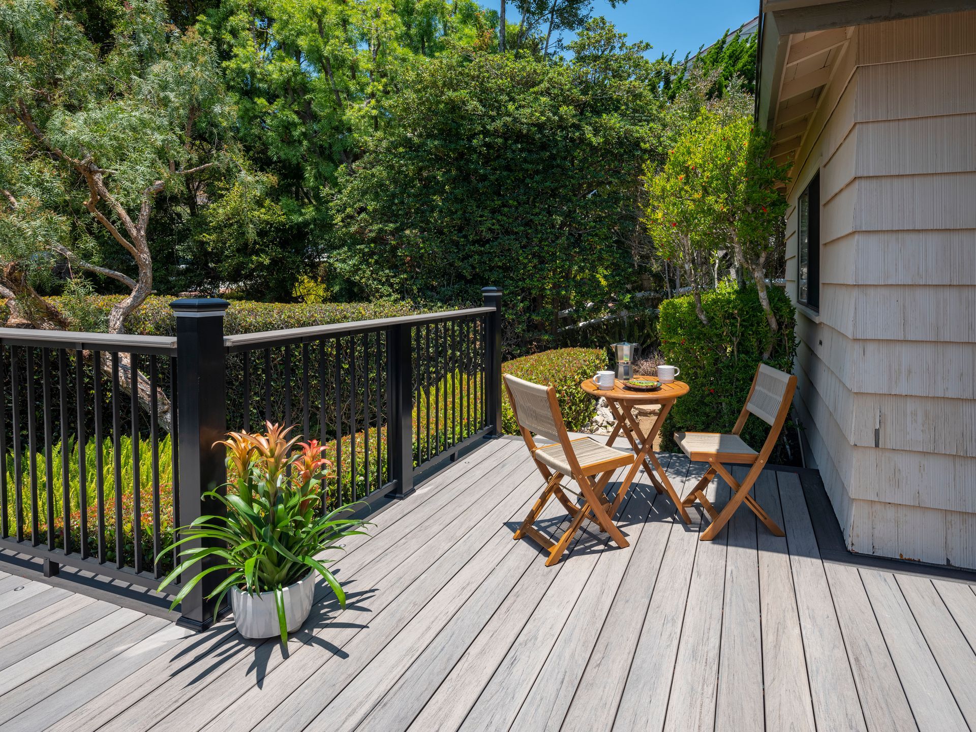 A wooden deck with a table and chairs on it.