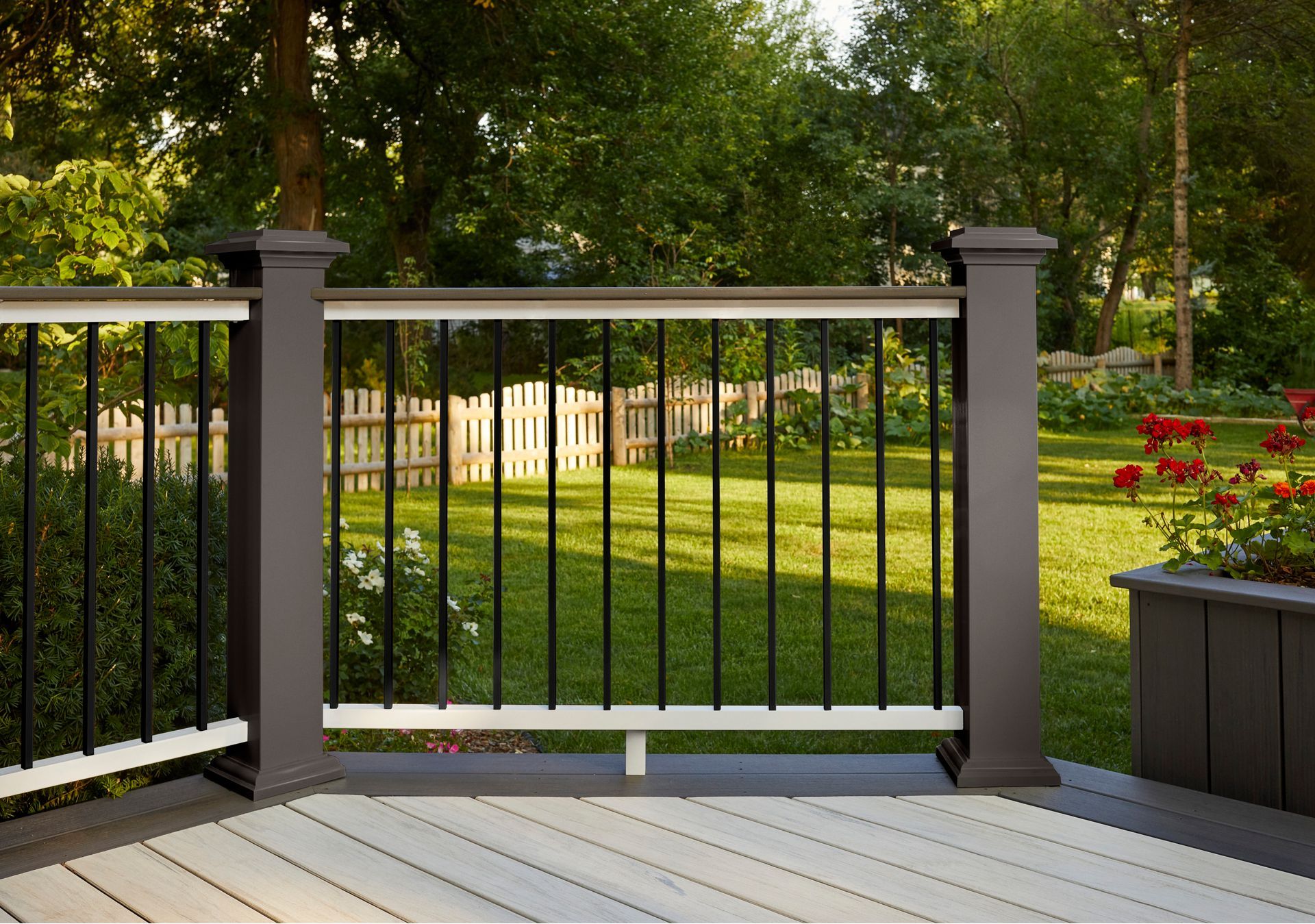 A deck with a black railing and a fence in the background