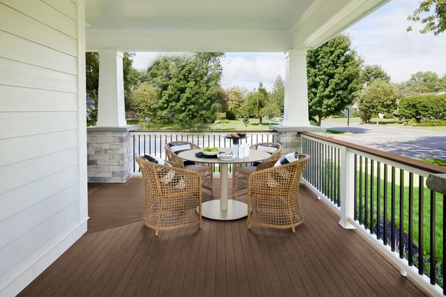 A porch with a table and chairs on it