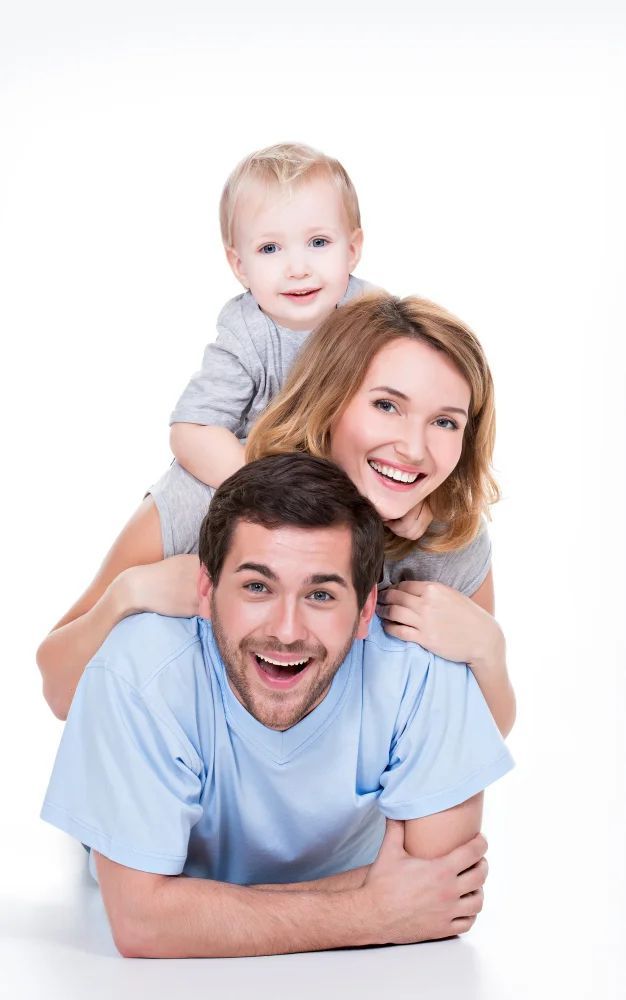 A man and a woman are laying on the floor with a baby on their shoulders.