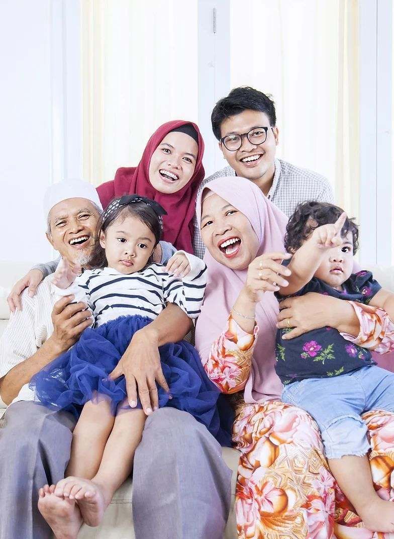 A family is posing for a picture while sitting on a couch.