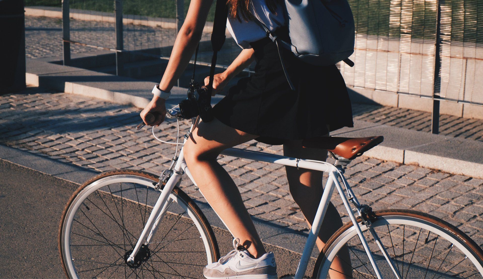 A woman is riding a bike with a backpack on her back