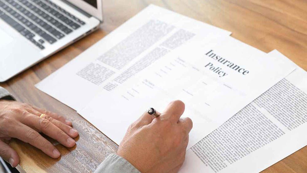 hand signing an insurance policy