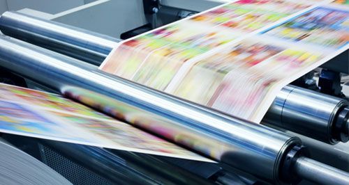Una máquina de impresión está imprimiendo muchos papeles de colores.