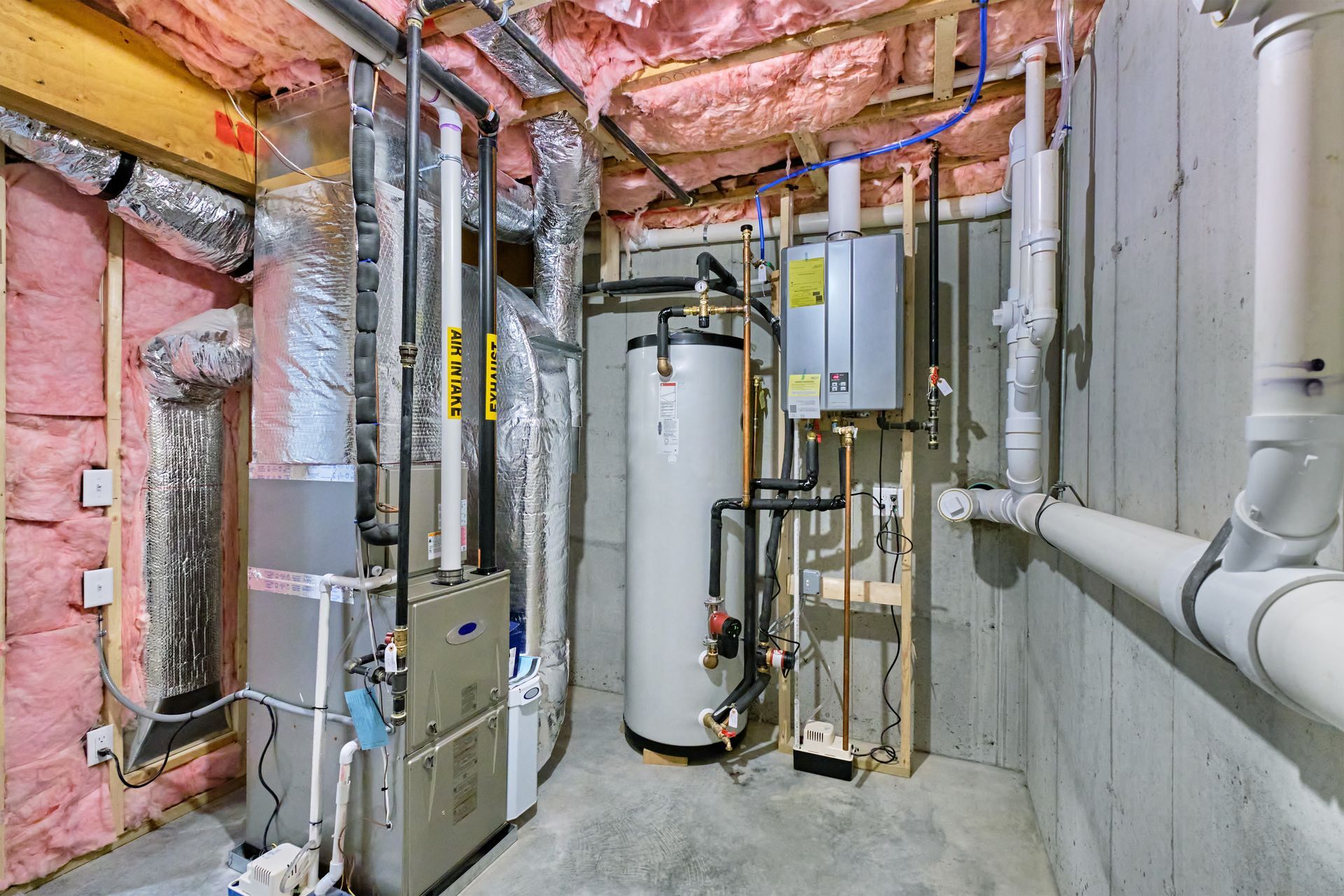 Furnace and other mechanical equipment in a basement with exposed wooden beams and pipes.