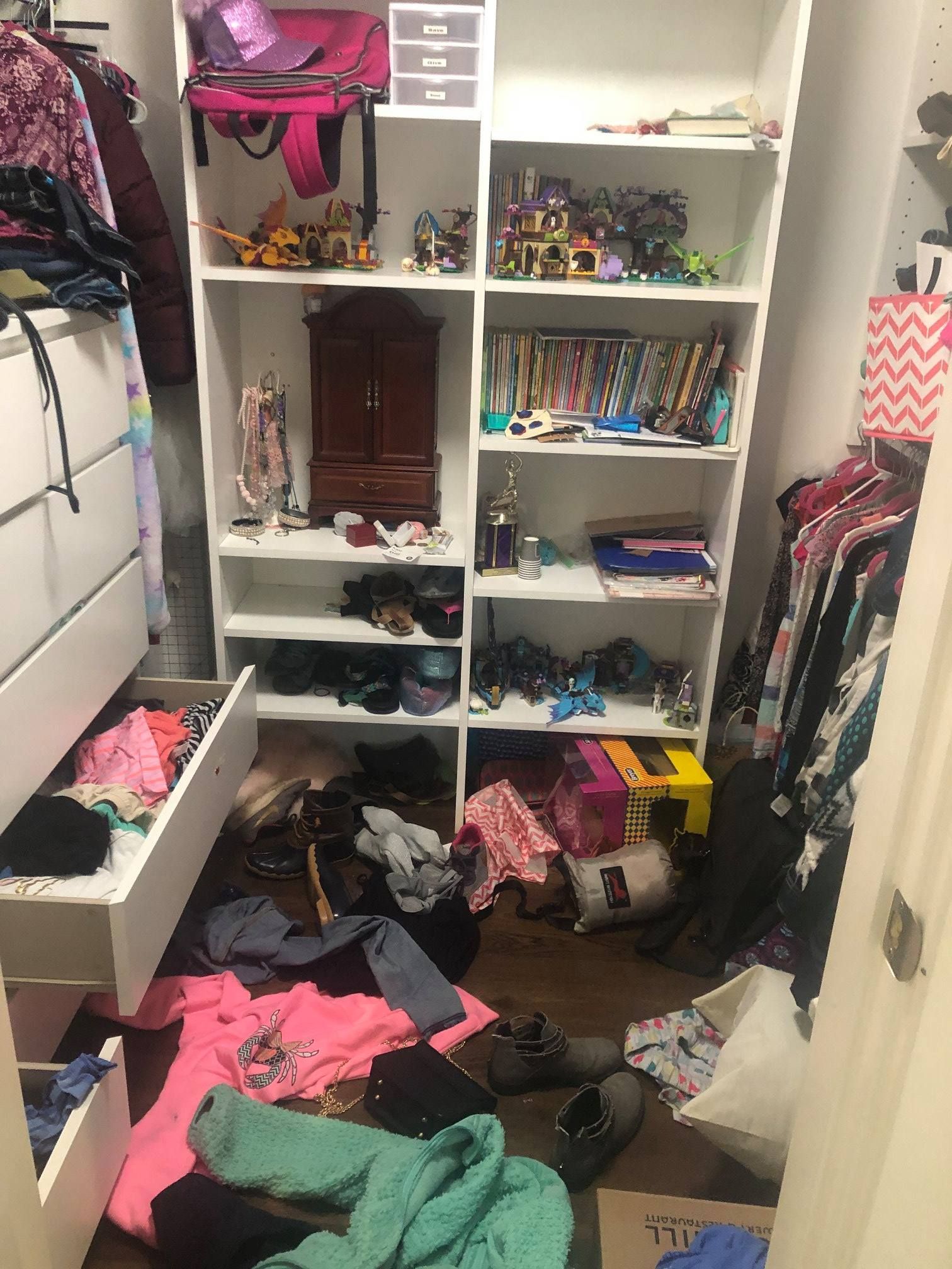 Messy closet with clothes on the floor, shelves with items, including a pink backpack, and shoe rack.