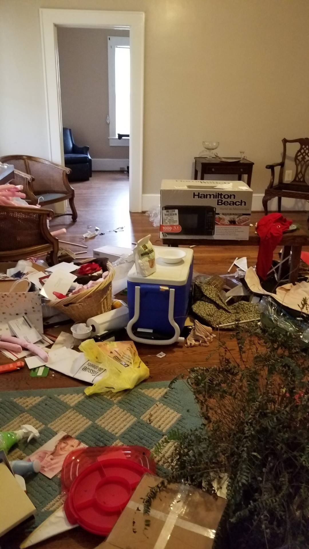 Messy room with scattered items, including a cooler, boxes, and debris.