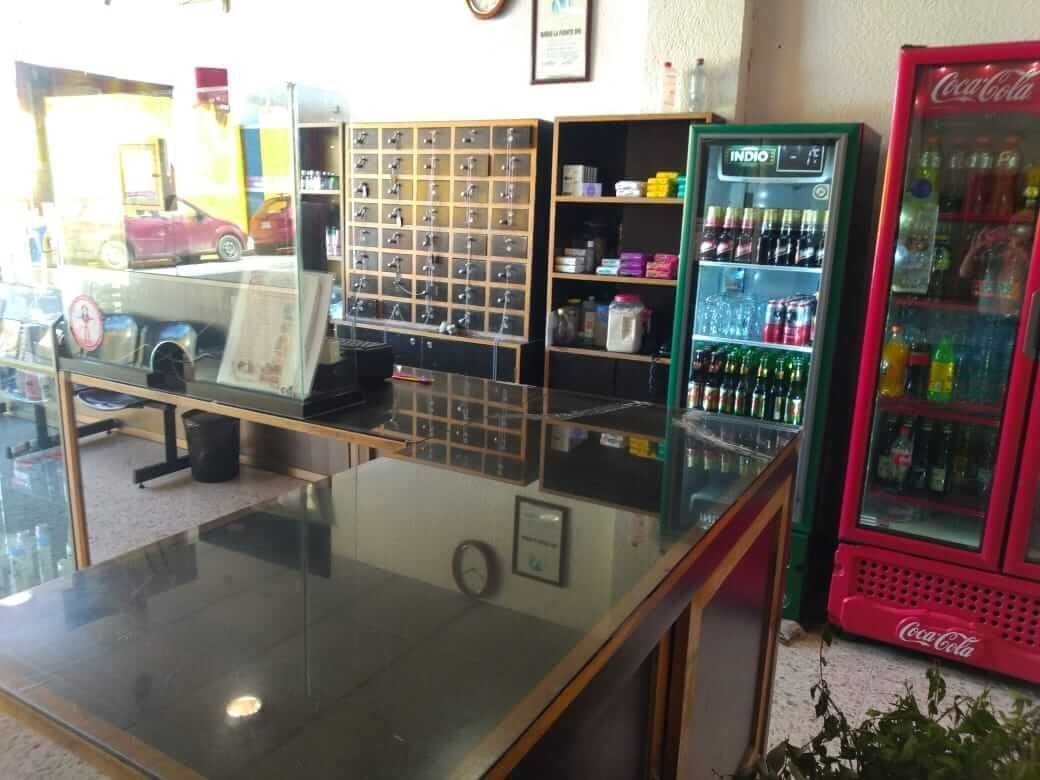 Un refrigerador de Coca Cola se encuentra junto a un mostrador en una tienda.