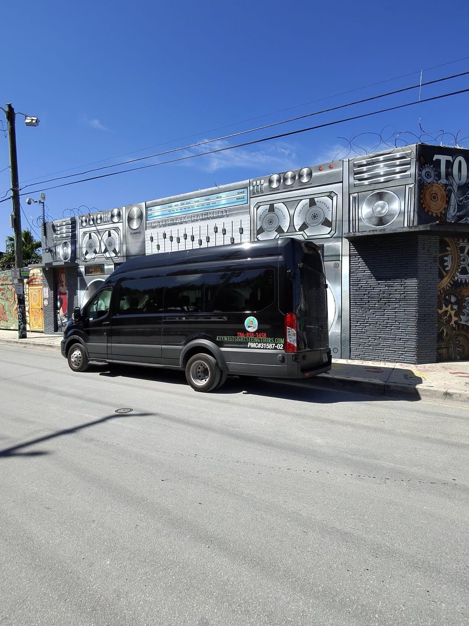 Miami Tour Bus parked in Wynwood with colorful street art in the background
