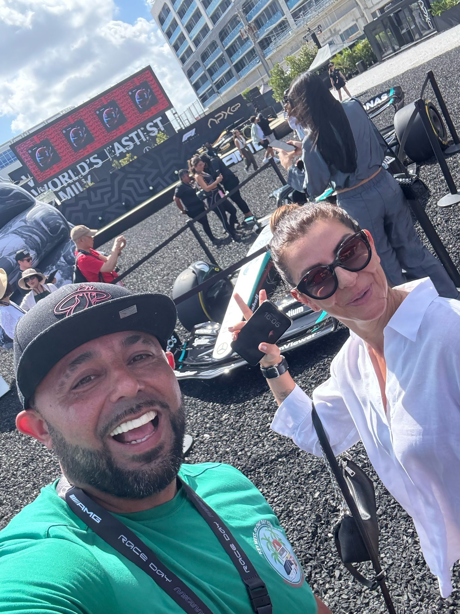 Tour Bus Miami guide and guest enjoying a sunny day at a Formula 1 race event, showcasing the fun side of the Miami sightseeing bus tour experience.
