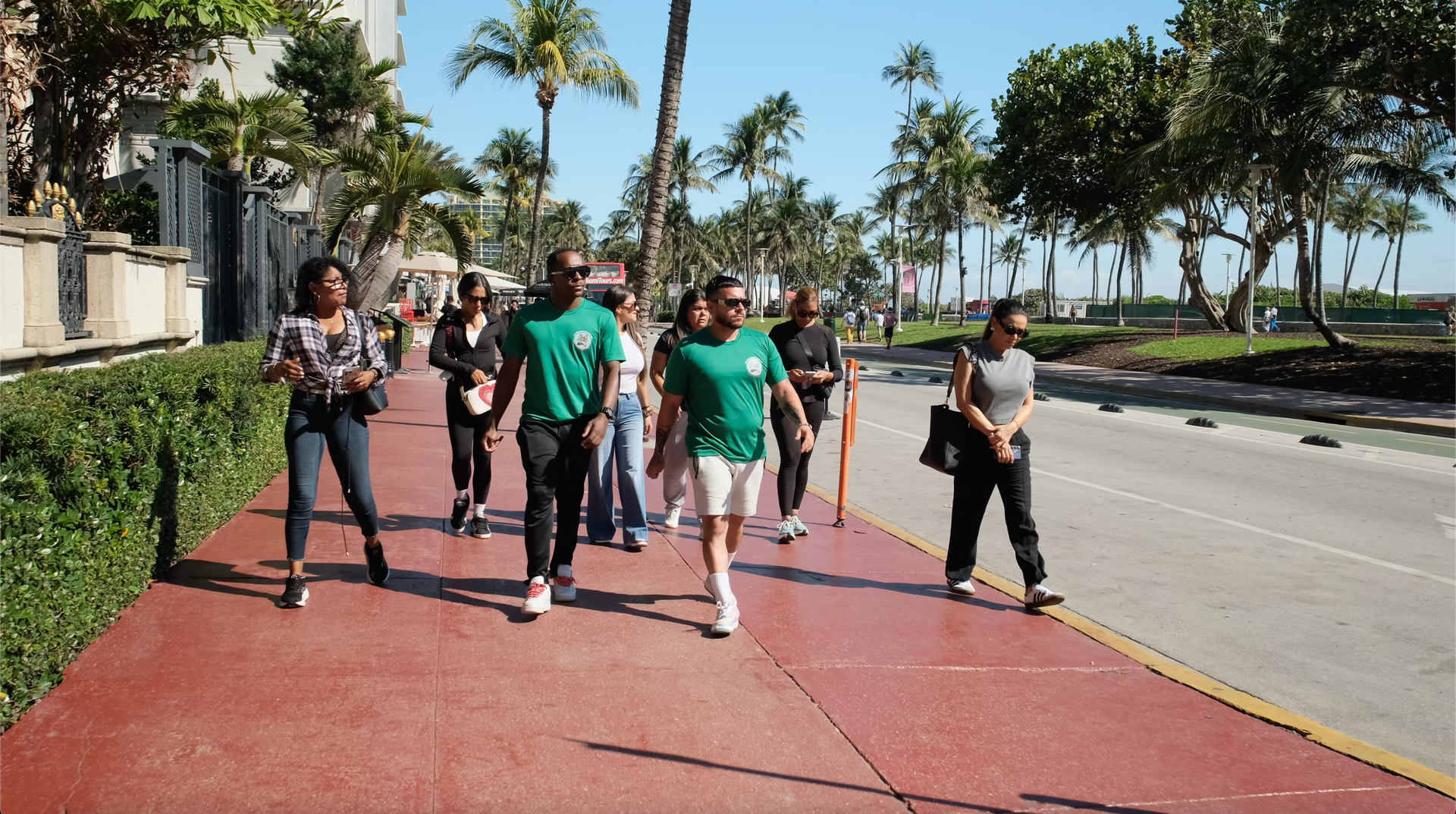 Miami Tour Bus tour guide and driver walking along Ocean Drive, leading a sightseeing tour
